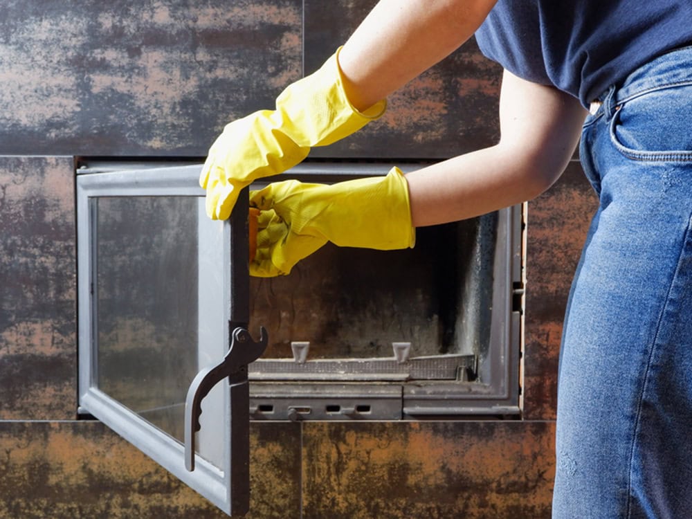 Close up of young woman in jeans, yellow gloves is cleaning