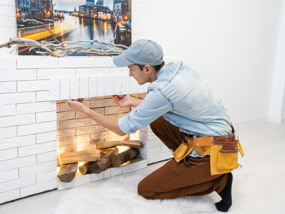 Service technician repairing a fireplace in a home